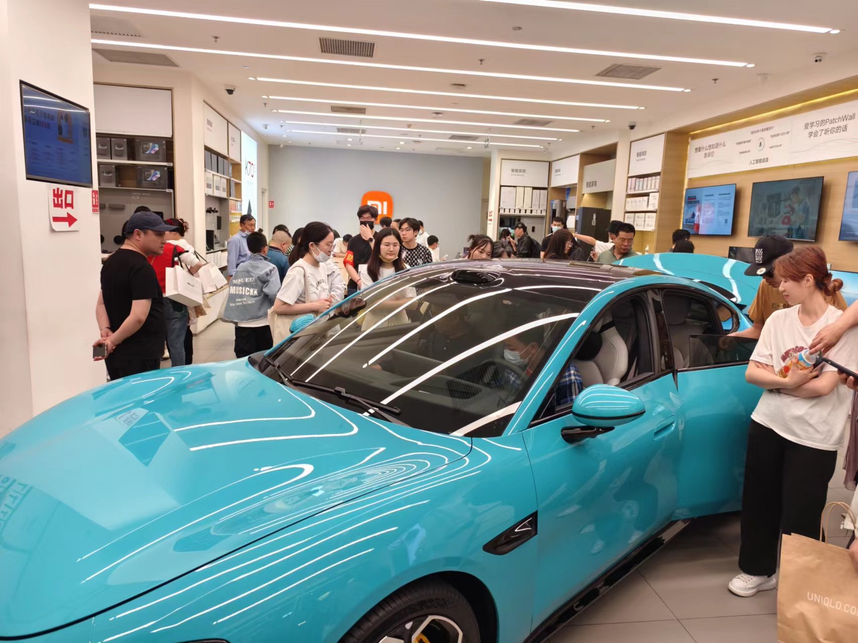 北京某商场新能源汽车展台,不少消费者前来咨询、体验。人民网记者 乔业琼摄