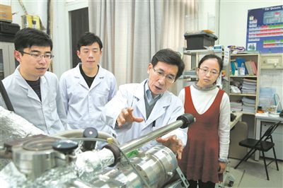 2017年10月,清华大学低维量子物理国家重点实验室,薛其坤(左三)与学生讨论实验工作。 苑洁摄