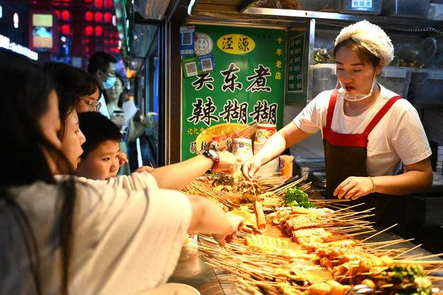 7月9日,游客在宁夏银川怀远夜市选购宁夏特色美食辣糊糊。新华社记者 毛竹摄