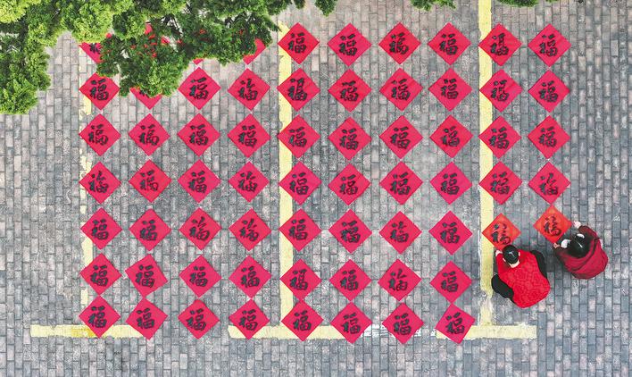 庐阳区林店街道金池社区党群服务中心,省书法家协会会员正在为居民义务写“福”字。 赵明 摄